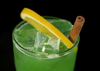 Green Cocktail with green juices, alcohol and lime wedge